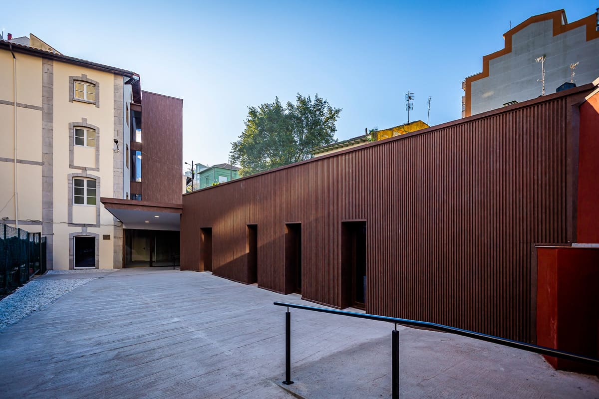Patio interior del Centro de Formación Ocupacional en Avilés con rampa y accesos tras el portón principal.